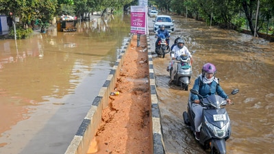 Vehicles move on a waterlogged road after heavy rain, in Bengaluru.&nbsp; (PTI)