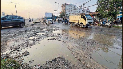 Commuters navigate through pothole-riddled service lane on Ludhiana-Jalandhar highway. (HT Photo)