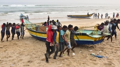 Fishermen shift their boats in anticipation of Cyclone Dana in Odisha’s Puri on Monday. (PTI) Fishermen shift their boats in anticipation of Cyclone Dana in Odisha’s Puri on Monday. (PTI)