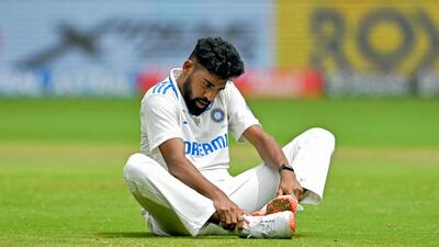 India fast bowler Mohammed Siraj cleans his spikes during the first Test against New Zealand at the M. Chinnaswamy Stadium in Bengaluru on Sunday. (AFP) India fast bowler Mohammed Siraj cleans his spikes during the first Test against New Zealand at the M. Chinnaswamy Stadium in Bengaluru on Sunday. (AFP)