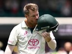 Australia's David Warner kisses the coat of arms on his helmet as he leaves the field in his last test match.