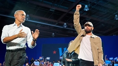 Rapper Eminem, center, greets the crowd on stage with former President Barack Obama, left, at a campaign rally supporting Democratic presidential nominee Vice President Kamala Harris, Tuesday, Oct. 22, 2024, in Detroit. (AP Photo/Paul Sancya) (AP) Rapper Eminem, center, greets the crowd on stage with former President Barack Obama, left, at a campaign rally supporting Democratic presidential nominee Vice President Kamala Harris, Tuesday, Oct. 22, 2024, in Detroit. (AP Photo/Paul Sancya) (AP)