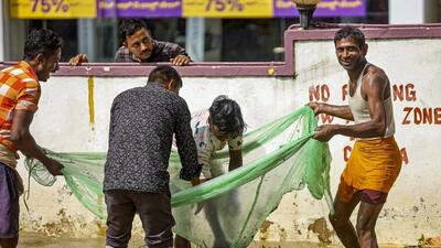 People catch fish in a waterlogged area after heavy rains at Yelahanka old town in Bengaluru. (PTI) People catch fish in a waterlogged area after heavy rains at Yelahanka old town in Bengaluru. (PTI)