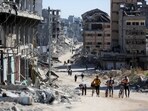 Palestinians make their way in a devasted neighbourhood amid the ongoing Israel-Hamas conflict, in Gaza City, October 24, 2024.