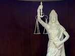 Lady Justice statue with its blindfold removed and a copy of the Constitution of India placed in her hand at the Supreme Court of India. 