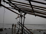 Cyclone Dana tracker: Police personnel stand guard ashore near a damaged shop at a beach in Balasore on October 24, 2024, hours before cyclone Dana hit the coasts of Odisha and West Bengal. Cyclone Dana tracker: Police personnel stand guard ashore near a damaged shop at a beach in Balasore on October 24, 2024, hours before cyclone Dana hit the coasts of Odisha and West Bengal.