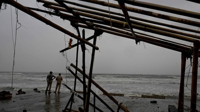Cyclone Dana tracker: Police personnel stand guard ashore near a damaged shop at a beach in Balasore on October 24, 2024, hours before cyclone Dana hit the coasts of Odisha and West Bengal. (AFP) Cyclone Dana tracker: Police personnel stand guard ashore near a damaged shop at a beach in Balasore on October 24, 2024, hours before cyclone Dana hit the coasts of Odisha and West Bengal. (AFP)