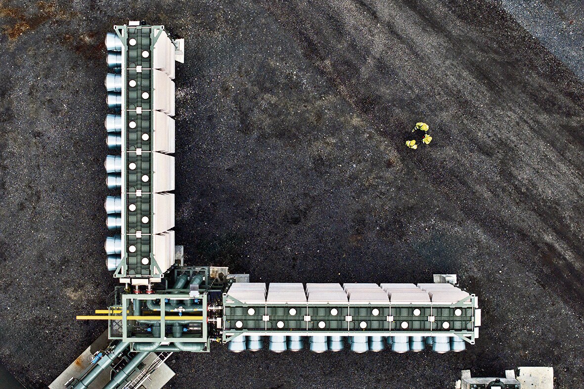 Three humans dwarfed by one of the arms of the Mammoth plant in Iceland. It is perhaps worth noting that the carbon being sucked out of the air by this plant is being traded, in the form of carbon credits. (Oli Haukur Myrdal / Climeworks) Three humans dwarfed by one of the arms of the Mammoth plant in Iceland. It is perhaps worth noting that the carbon being sucked out of the air by this plant is being traded, in the form of carbon credits. (Oli Haukur Myrdal / Climeworks)