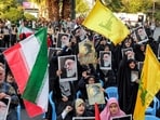 Demonstrators wave flags of Iran, Lebanese Hezbollah, and pictures of Iran's Supreme Leader Ayatollah Ali Khamenei during an anti-Israel rally in Tehran on October 24, 2024.