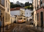 A tram drives in Alfama neighborhood in Lisbon. The iconic Lisbon's yellow trams turned into a touristic attraction at the expense of locals who can no longer find their place. A tram drives in Alfama neighborhood in Lisbon. The iconic Lisbon's yellow trams turned into a touristic attraction at the expense of locals who can no longer find their place.