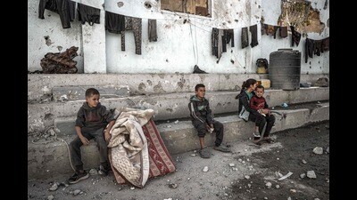 A boy sits next to a mattress and blankets with other children in the yard of the Shuhada (Martyrs) school, which was hit by Israeli bombardment, in Nuseirat in the central Gaza Strip on October 24, 2024 amid the ongoing war in the Palestinian territory between Israel and Hamas. (Photo by Eyad BABA / AFP) (AFP) A boy sits next to a mattress and blankets with other children in the yard of the Shuhada (Martyrs) school, which was hit by Israeli bombardment, in Nuseirat in the central Gaza Strip on October 24, 2024 amid the ongoing war in the Palestinian territory between Israel and Hamas. (Photo by Eyad BABA / AFP) (AFP)