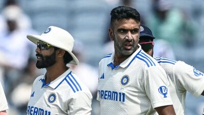 India's Ravichandran Ashwin (R) looks on after taking the wicket of New Zealand's Devon Conway during the first day of the second Test (AFP)