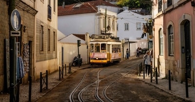 A tram drives in Alfama neighborhood in Lisbon. The iconic Lisbon's yellow trams turned into a touristic attraction at the expense of locals who can no longer find their place. (Photo by Patricia DE MELO MOREIRA / AFP) A tram drives in Alfama neighborhood in Lisbon. The iconic Lisbon's yellow trams turned into a touristic attraction at the expense of locals who can no longer find their place. (Photo by Patricia DE MELO MOREIRA / AFP)