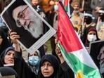 A woman holds a Palestinian flag and a picture of Iran's Supreme Leader Ayatollah Ali Khamenei during an anti-Israel rally in Tehran. (Photo by AFP)