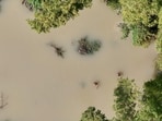 An aerial view of people wading through a flooded area in Philippines An aerial view of people wading through a flooded area in Philippines