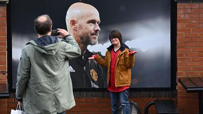 A visitor reacts as he poses in front of a picture of newly sacked Manchester United manager Erik ten Hag. (AFP) A visitor reacts as he poses in front of a picture of newly sacked Manchester United manager Erik ten Hag. (AFP)