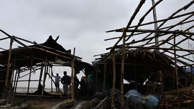 Villagers stand near damaged temporary houses following the landfall of cyclone Dana in East Midnapore district around 180km southwest of Kolkata, on October 25, 2024. Cyclone Dana uprooted trees and power lines after making landfall on India's east coast, with officials warning of more fierce weather on October 25. (Photo by DIBYANGSHU SARKAR / AFP) (AFP) Villagers stand near damaged temporary houses following the landfall of cyclone Dana in East Midnapore district around 180km southwest of Kolkata, on October 25, 2024. Cyclone Dana uprooted trees and power lines after making landfall on India's east coast, with officials warning of more fierce weather on October 25. (Photo by DIBYANGSHU SARKAR / AFP) (AFP)