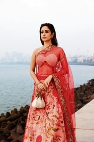 Outfit: Asha Gautam
Nushrratt looks elegant in a beige silk tissue Paithani lehenga. Its Nature-inspired motifs complement the pearl-embellished blouse and a red net dupatta featuring zardozi French knots and resham embroidery from Asha Gautam
Potli: The Tan Clan
The actor pairs her lehenga with a handcrafted lotus-shaped potli from The Tan Clan, embroidered in white pearl, which celebrate individuality Outfit: Asha Gautam
Nushrratt looks elegant in a beige silk tissue Paithani lehenga. Its Nature-inspired motifs complement the pearl-embellished blouse and a red net dupatta featuring zardozi French knots and resham embroidery from Asha Gautam
Potli: The Tan Clan
The actor pairs her lehenga with a handcrafted lotus-shaped potli from The Tan Clan, embroidered in white pearl, which celebrate individuality