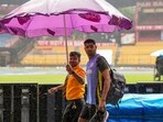 A security guard holds an umbrella to cover cricketer Harshit Rana as it rains at the M Chinnaswamy Stadium, ahead of the first test match between India and New Zealand A security guard holds an umbrella to cover cricketer Harshit Rana as it rains at the M Chinnaswamy Stadium, ahead of the first test match between India and New Zealand