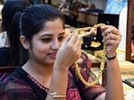 Dhanteras 2024 dos and don'ts: A woman shops for gold jewelry at a showroom ahead of the Dhanteras festival, in Guwahati.