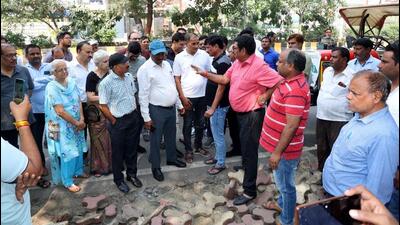 Acting in compliance with NGT directives citing environmental concerns associated with concrete covered surfaces, Noida authority on Monday began removing tiles from footpaths. But RWA members objected, citing possible dust pollution due to it. (HT Photo)
