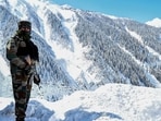 Indian soldier stands on a snow-covered road near Zojila mountain pass that connects Srinagar to the union territory of Ladakh.