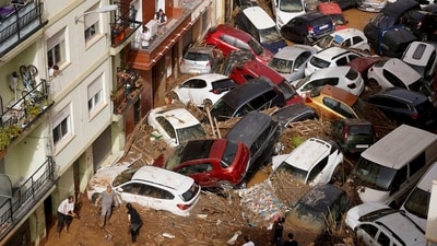 Residents clean the street next to cars piled up after being swept away by floods in Valencia. (AP) Residents clean the street next to cars piled up after being swept away by floods in Valencia. (AP)