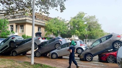 Residents walk near piled up cars following flood in Picanya, near Valencia, eastern Spain, (AFP) Residents walk near piled up cars following flood in Picanya, near Valencia, eastern Spain, (AFP)