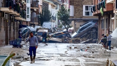 Residents are pictured next to cars piled in a street covered in mud following floods in Picanya. (AFP) Residents are pictured next to cars piled in a street covered in mud following floods in Picanya. (AFP)
