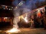A boy plays with firecrackers inside a chawl during Diwali, the Hindu festival of lights, in Mumbai