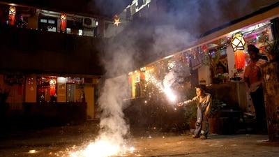 A boy plays with firecrackers inside a chawl during Diwali, the Hindu festival of lights, in Mumbai (REUTERS)