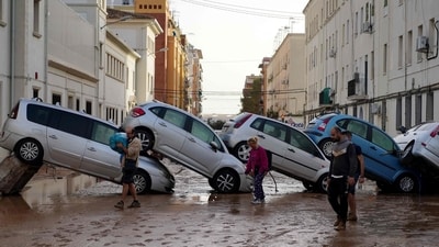 Residents walk past piled up cars following deadly floods in Valencia's De La Torre neighbourhood, south of Valencia, eastern Spain, on October 30, 2024. (AFP) Residents walk past piled up cars following deadly floods in Valencia's De La Torre neighbourhood, south of Valencia, eastern Spain, on October 30, 2024. (AFP)
