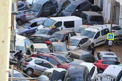Persons climb on piled up cars following deadly floods in Sedavi, south of Valencia. (AFP) Persons climb on piled up cars following deadly floods in Sedavi, south of Valencia. (AFP)