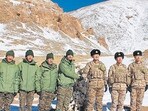 Indian and Chinese army soldiers exchange sweets along the Line of Actual Control (LAC) near Karakoram pass in Ladakh on Thursday. (AFP)