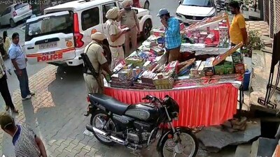 In the video, three cops can be seen reaching a firecracker shop. While two cops start talking with the shop owner and also making a video of the stall on their phone. However, in the meantime, the third cop picked up some firecrackers from the shop and put them in the official vehicle. (Video grab)