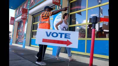 MIAMI, FLORIDA - OCTOBER 21: A poll worker directs a voter to a polling station set up inside of the Little Haiti Cultural Complex as Early Voting begins on October 21, 2024, in Miami, Florida. Early voting runs from Oct. 21 through Nov. 3 in Miami-Dade and Broward. People head to the polls to decide, among other races, the next president of the United States. Joe Raedle/Getty Images/AFP (Photo by JOE RAEDLE / GETTY IMAGES NORTH AMERICA / Getty Images via AFP) (Getty Images via AFP)
