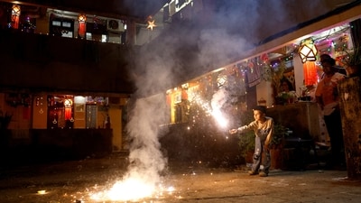 A boy plays with firecrackers inside a chawl during Diwali, the Hindu festival of lights, in Mumbai despite pollution concerns. (REUTERS)