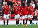 Manchester United players applaud fans after a match.