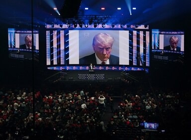 The mugshot of Republican presidential nominee and former U.S. President Donald Trump is displayed on screens at a campaign event for Trump sponsored by conservative group Turning Point USA, in Duluth, Georgia, U.S., October 23, 2024. (Reuters)