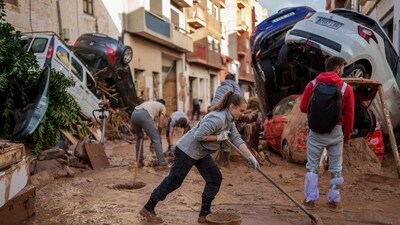 People clean the street of mud in an area affected by floods in Paiporta. (AP) People clean the street of mud in an area affected by floods in Paiporta. (AP)