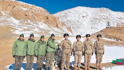 Indian and Chinese army soldiers exchange sweets along the Line of Actual Control (LAC) near Karakoram pass in Ladakh on Thursday. (AFP)