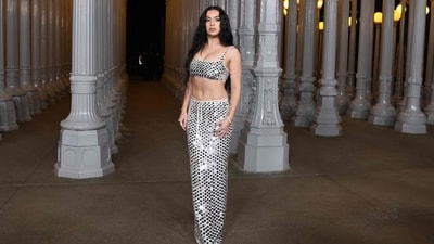 Charli XCX made a glittering entrance at the LACMA Art+Film Gala in a custom Gucci look featuring of a mirrored bra top and matching maxi skirt. A diamond-encrusted bracelet and rings completed her look. The Brat singer wore her dark tresses in waves, while her makeup featured smudged black eyeliner and nude lip liner. (AFP) Charli XCX made a glittering entrance at the LACMA Art+Film Gala in a custom Gucci look featuring of a mirrored bra top and matching maxi skirt. A diamond-encrusted bracelet and rings completed her look. The Brat singer wore her dark tresses in waves, while her makeup featured smudged black eyeliner and nude lip liner. (AFP)