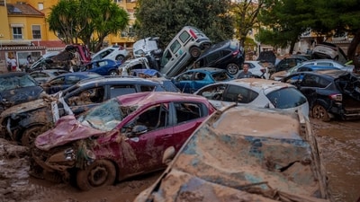 A man stands next to piled-up cars in an area affected by floods in Benetusser, Spain. (AP) A man stands next to piled-up cars in an area affected by floods in Benetusser, Spain. (AP)