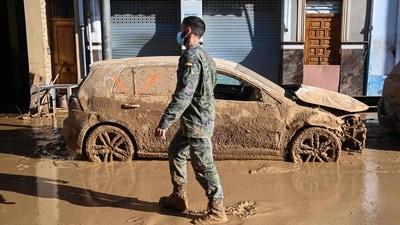 A soldier walks past a flood damaged car in Massanassa, in the region of Valencia. (AFP) A soldier walks past a flood damaged car in Massanassa, in the region of Valencia. (AFP)