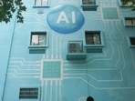 A woman walks past a building whose exterior wall was painted to look like a circuit board with an AI logo in Hangzhou, in China's eastern Zhejiang province. (AFP)