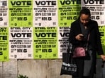A woman waits for the bus before a wall covered with posters encouraging people to vote in Pittsburgh, Pennsylvania, on November 4, 2024, one day before the US presidential election. (Photo by Charly TRIBALLEAU / AFP) A woman waits for the bus before a wall covered with posters encouraging people to vote in Pittsburgh, Pennsylvania, on November 4, 2024, one day before the US presidential election. (Photo by Charly TRIBALLEAU / AFP)