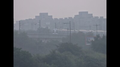 A metro train runs on its tracks amid smog, in Gurugram on Monday. (PTI) A metro train runs on its tracks amid smog, in Gurugram on Monday. (PTI)