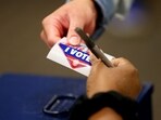 A poll worker hands a voter an 'I Voted' sticker at a polling booth in Nevada.(Bloomberg)