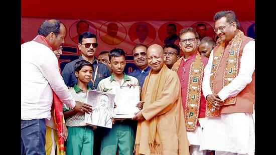 Chief minister Yogi Adityanath being presented with a handmade portrait of himself during a public meeting for Jharkhand assembly elections, at Barkagaon, in Hazaribagh on Tuesday. (ANI Phot)