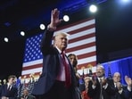 Republican presidential nominee former President Donald Trump waves as he walks with former first lady Melania Trump at an election night watch party at the Palm Beach Convention Center, on Wednesday (AP)